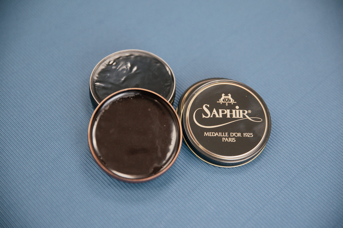Saphir Medaille d'Or 1925 Pate De Luxe paste wax shoe polish in black and burgundy displayed on blue backdrop