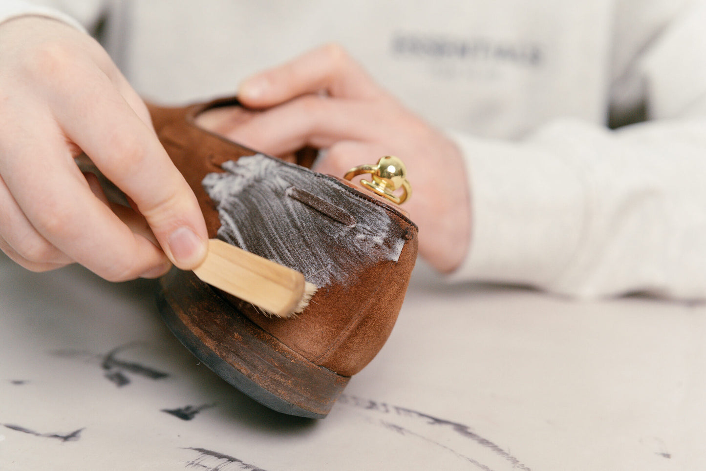 Crockett & Jones polo snuff suede cavendish loafer shown with Saphir crepe brush, omni'nettoyant suede cleaner, and saphir MDO horsehair mini welt brush and Saphir Cedar Shoe trees being brushed to show cleaning